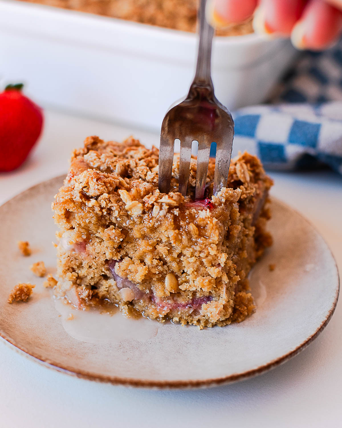Strawberry coffee cake slice with crumb topping and fresh strawberries inside