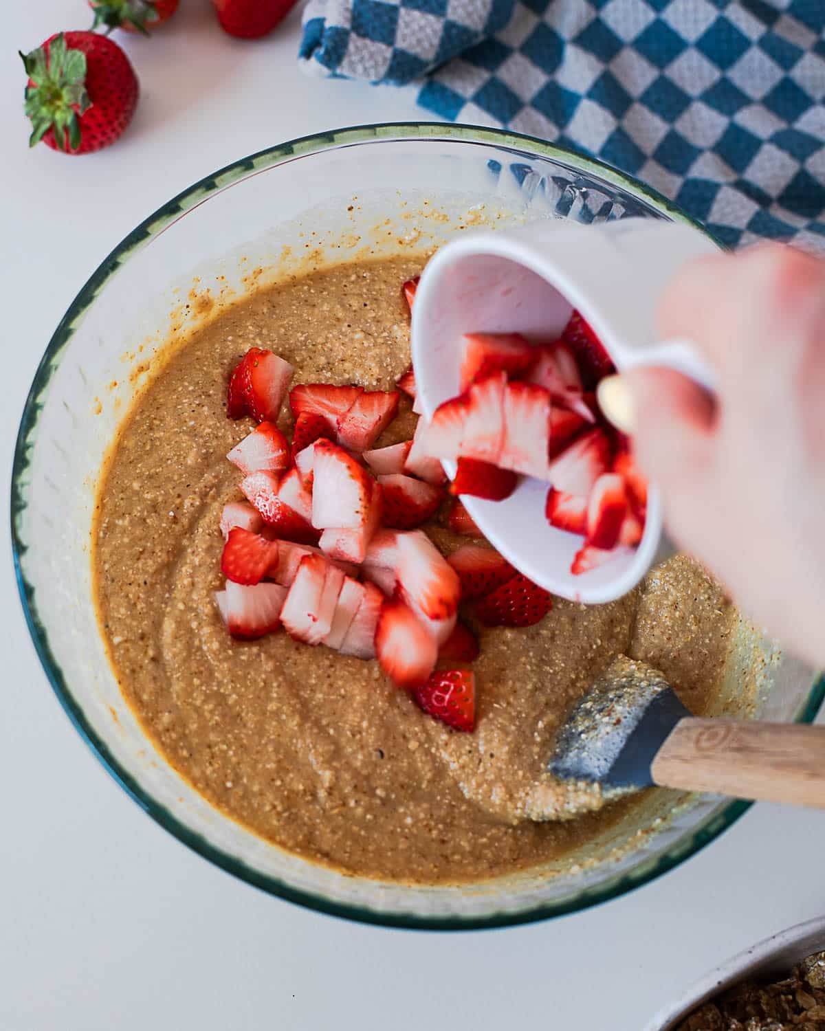 Fresh diced strawberries being added into coffee cake batter