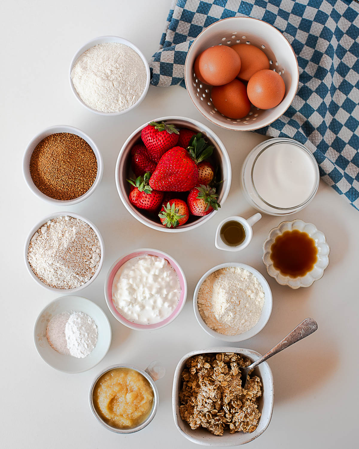 Ingredients for strawberry crumb coffee cake including flours, eggs, strawberries, and cottage cheese