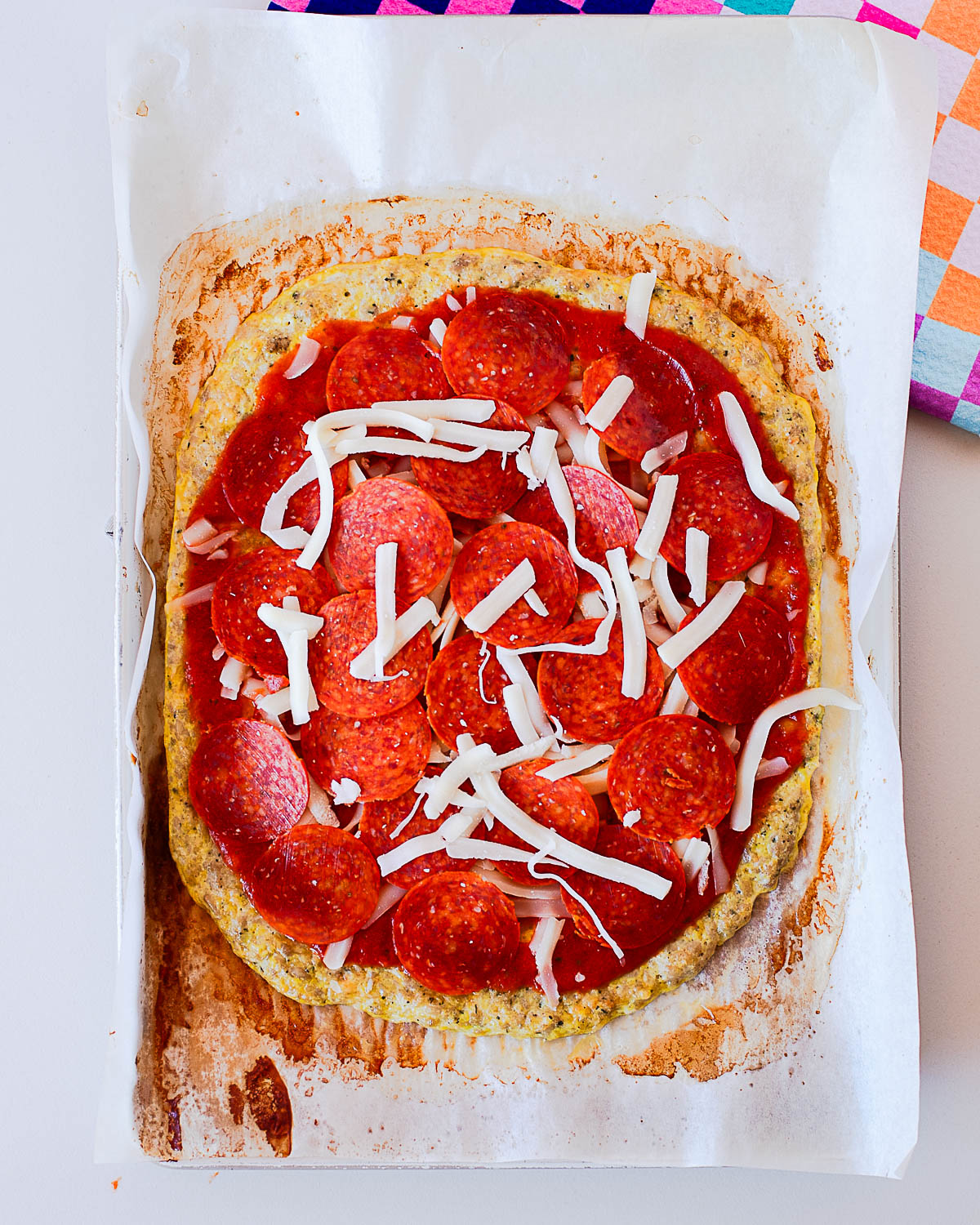 Chicken crust pizza topped with pizza sauce, mozzarella cheese, and pepperoni before the final bake.