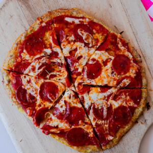 Whole chicken crust pepperoni pizza cut into slices with crispy edges and melted cheese.