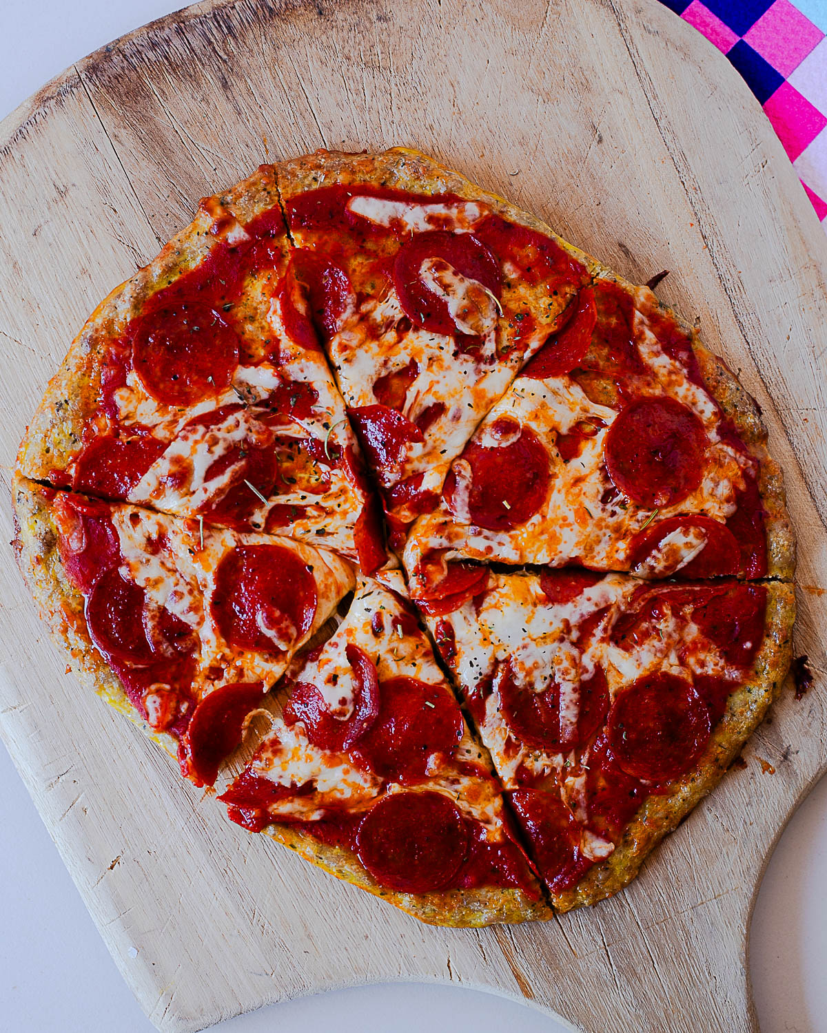 Whole chicken crust pepperoni pizza cut into slices with crispy edges and melted cheese.