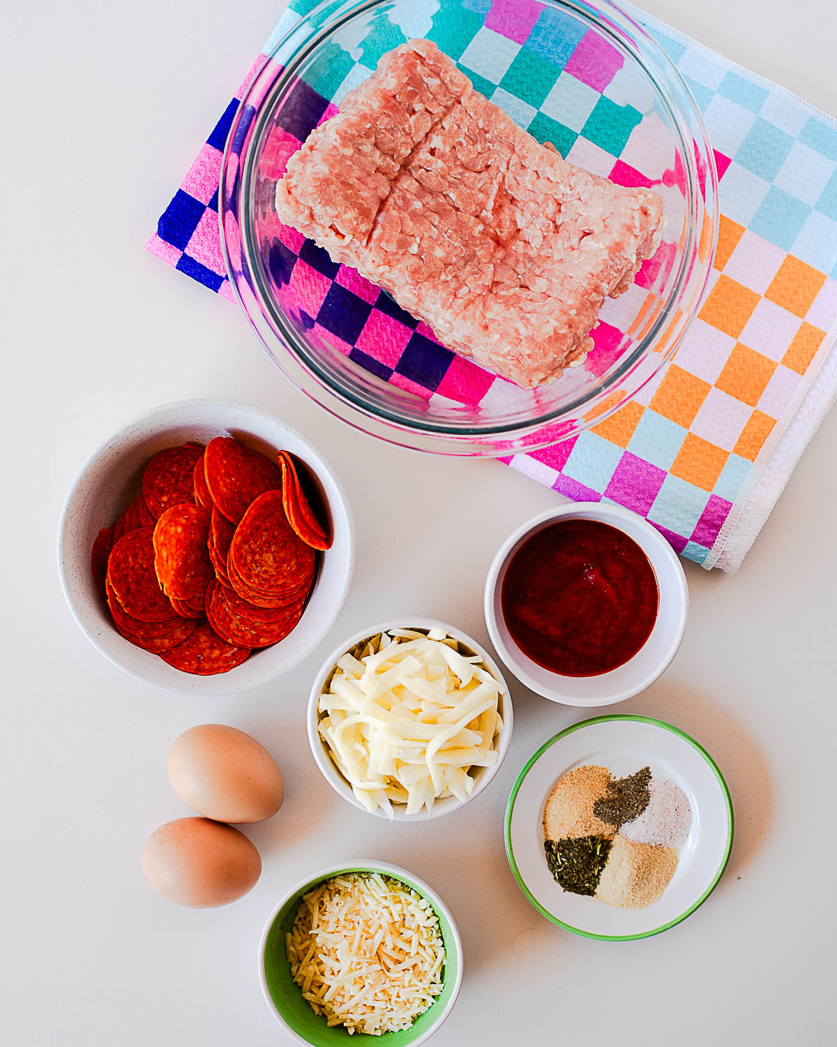 Ingredients for chicken crust pepperoni pizza including ground chicken, eggs, mozzarella, parmesan, pizza sauce, pepperoni, and seasonings.