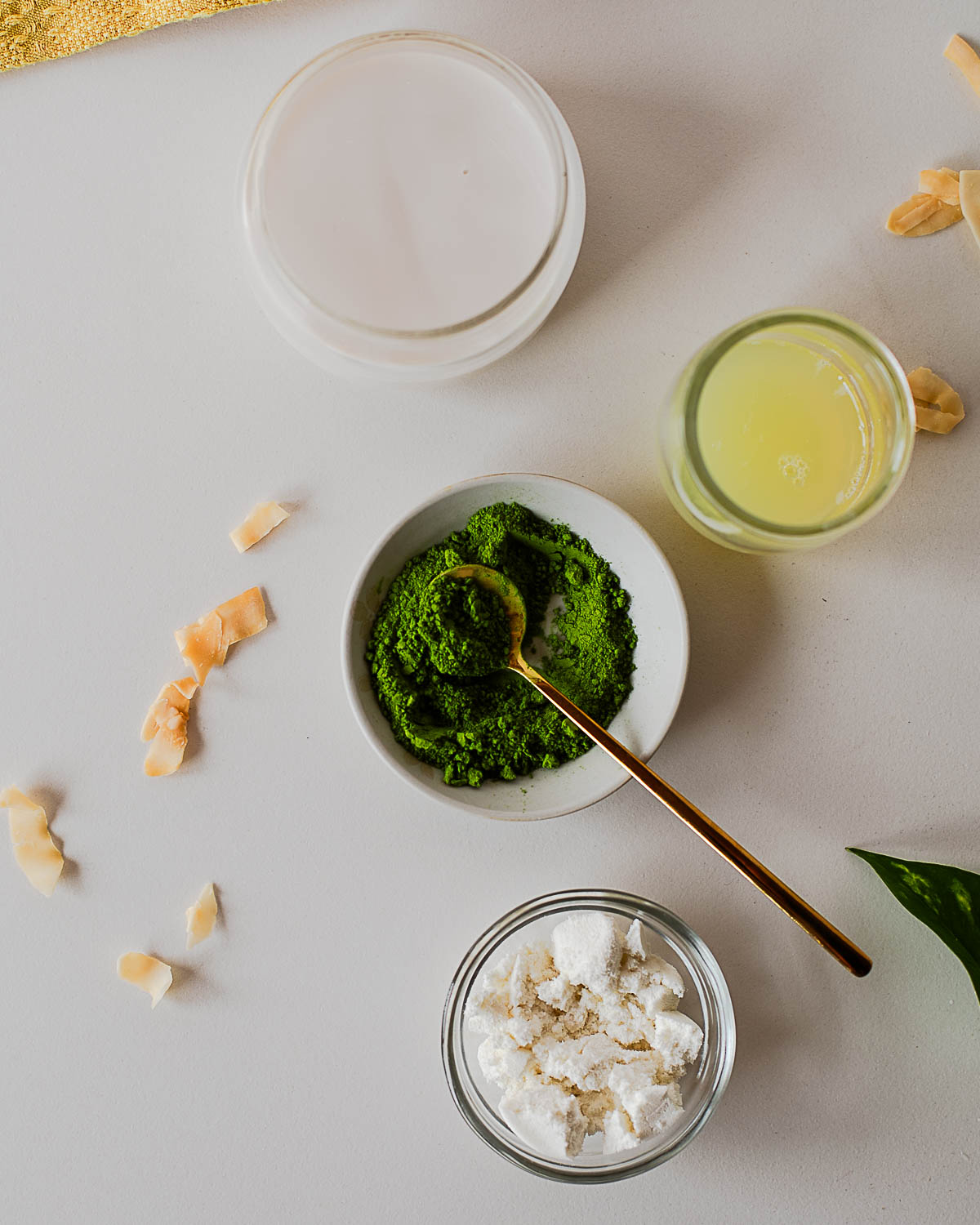 Ingredients for an iced coconut protein matcha latte including ceremonial grade matcha powder, protein powder, and liquid egg whites.