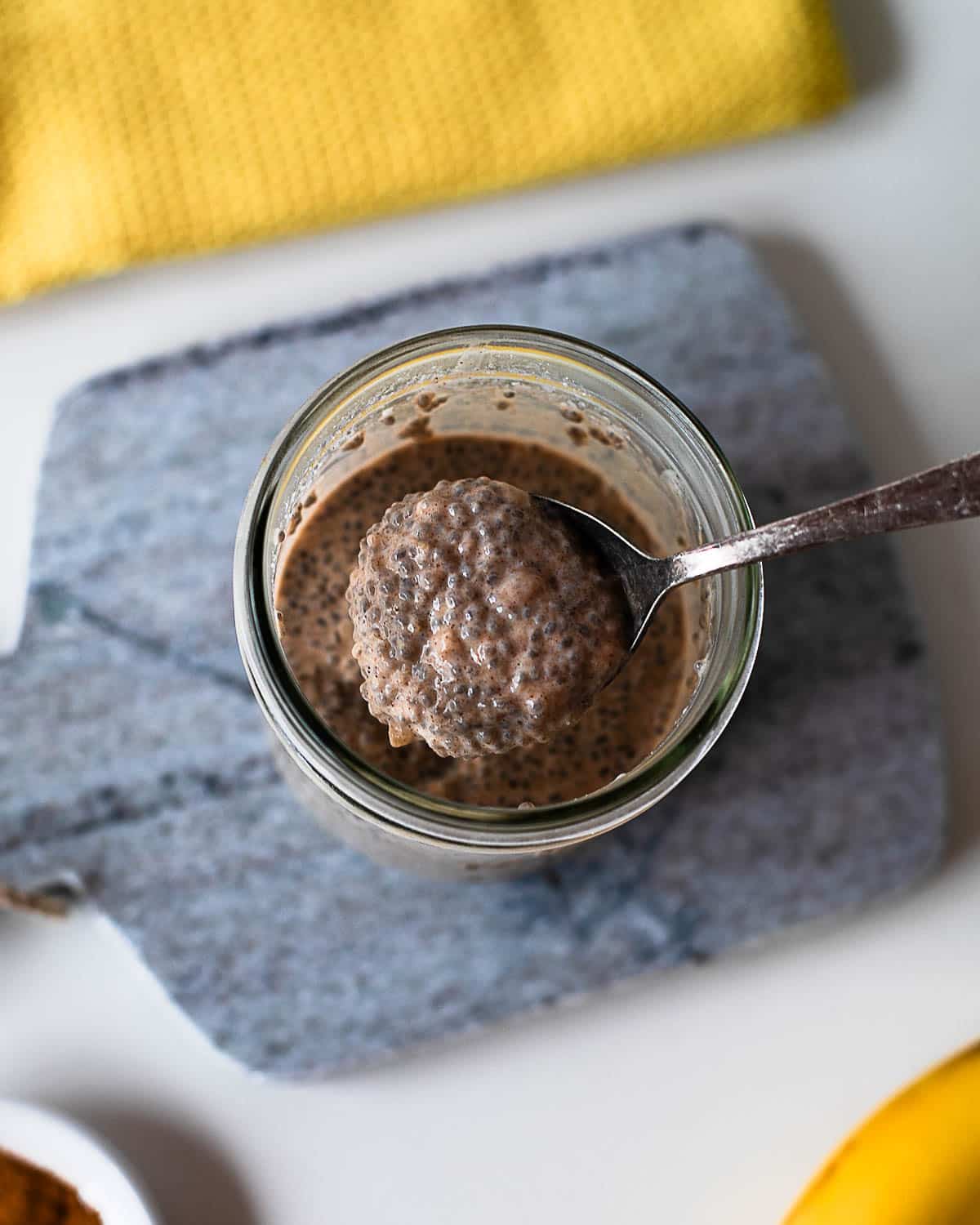 Close-up spoonful of thick and creamy banana chia pudding showing the rich texture of chia seeds and mashed banana.