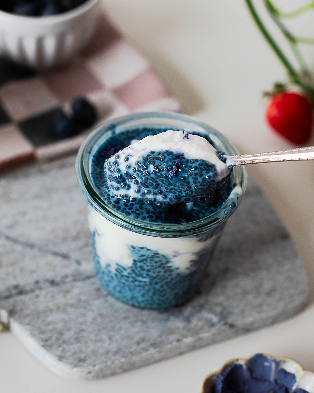 Spoonful of creamy blue chia pudding with Greek yogurt showing the thick texture and vibrant natural blue color.