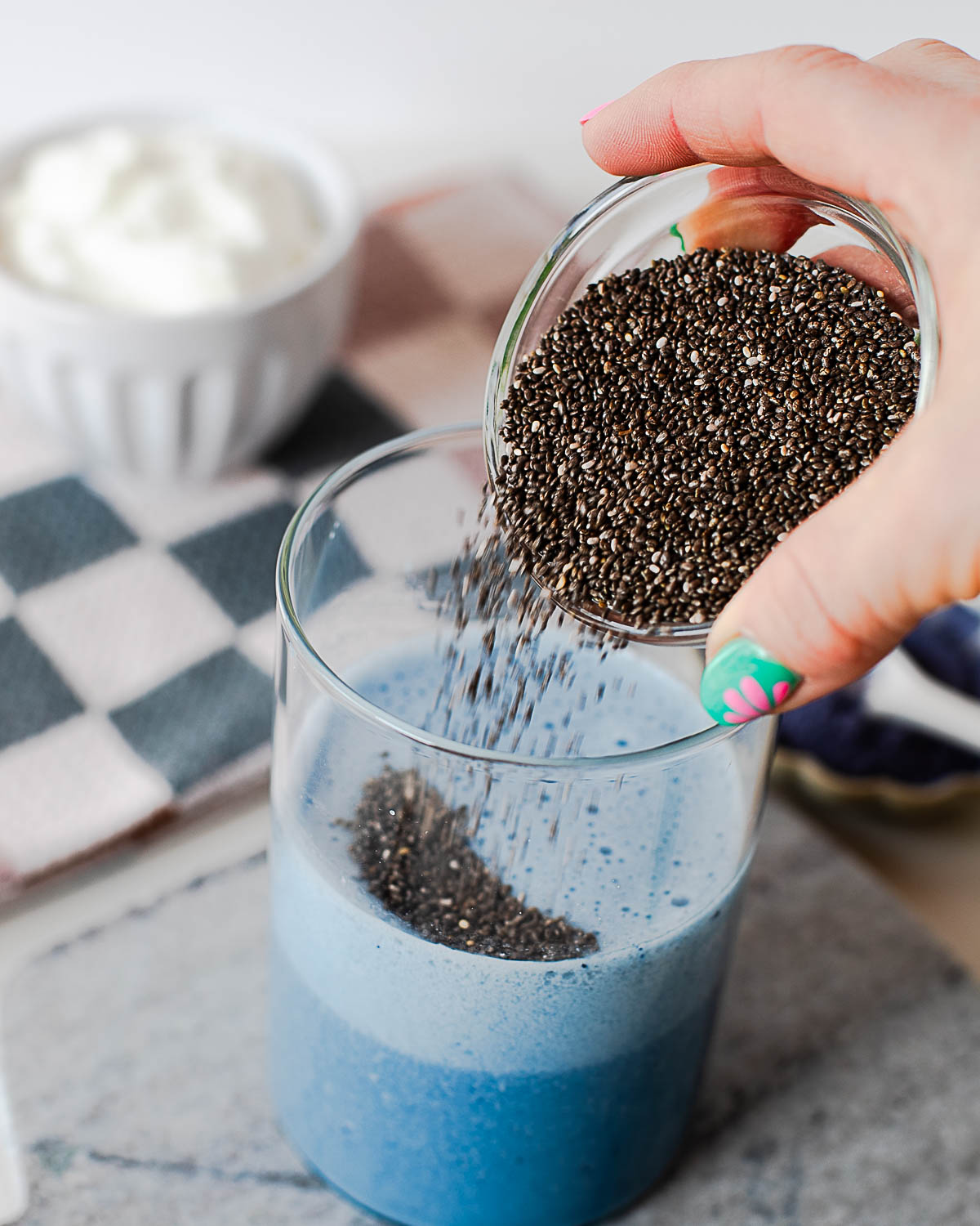 Blue chia pudding mixture setting in a glass jar before chilling, ready to thicken into a creamy breakfast.