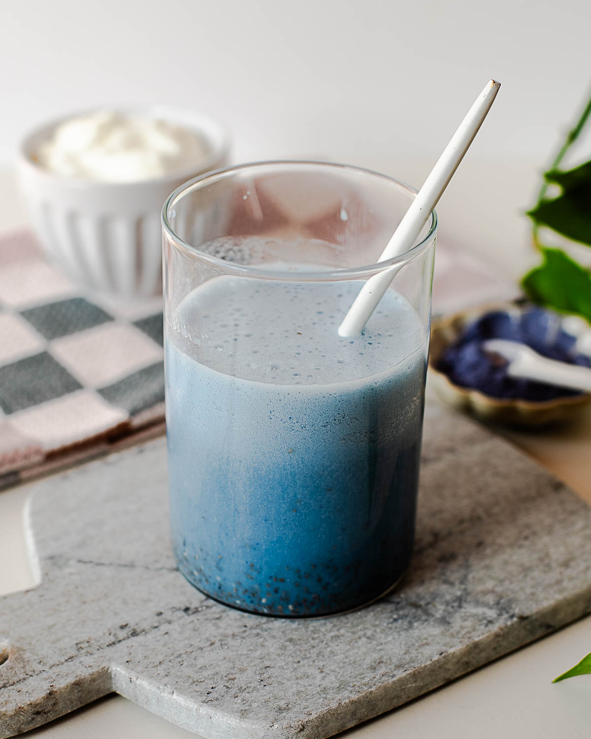 Stirring chia seeds into a vibrant blue chia pudding mixture made with almond milk, protein powder, and butterfly pea powder.