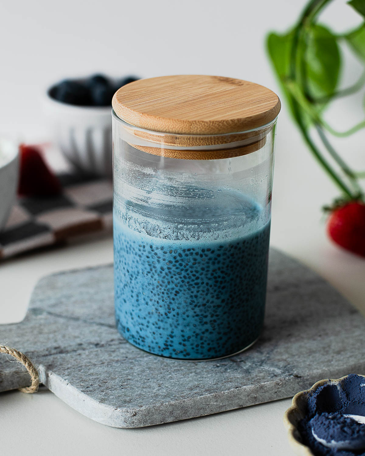 Blue chia pudding mixture setting in a glass jar before chilling, ready to thicken into a creamy breakfast.