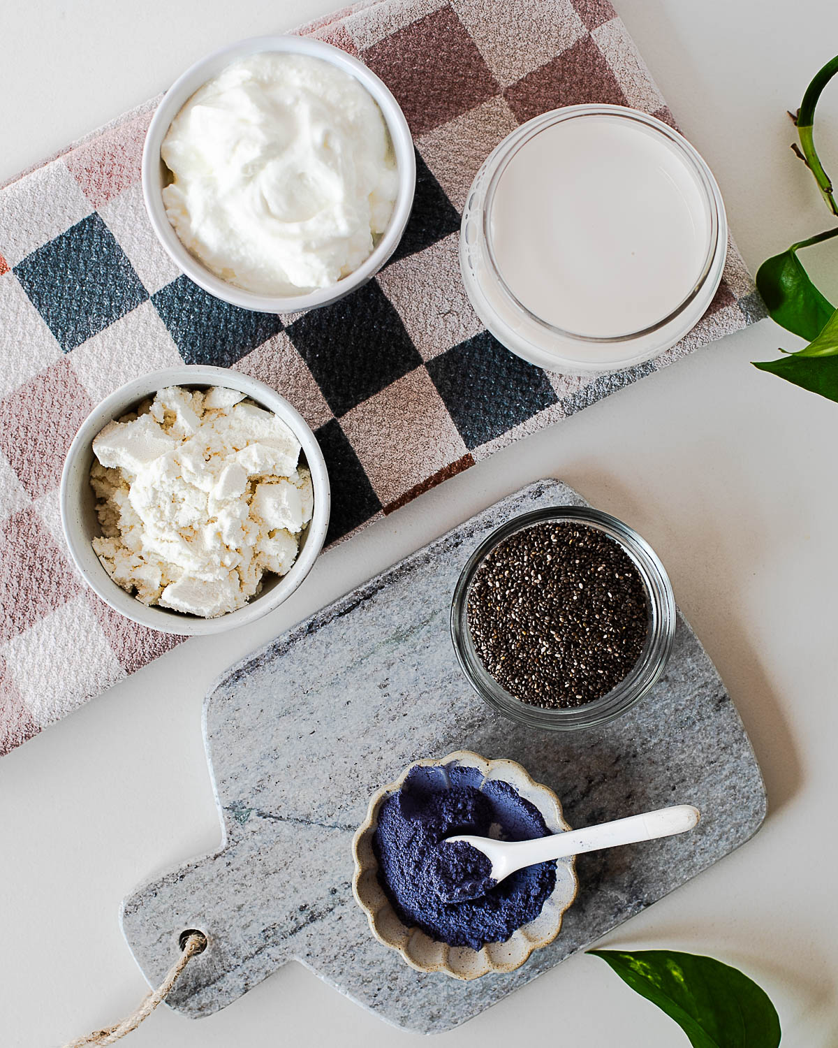 Ingredients for blue chia pudding including chia seeds, almond milk, vanilla protein powder, Greek yogurt, and butterfly pea powder.