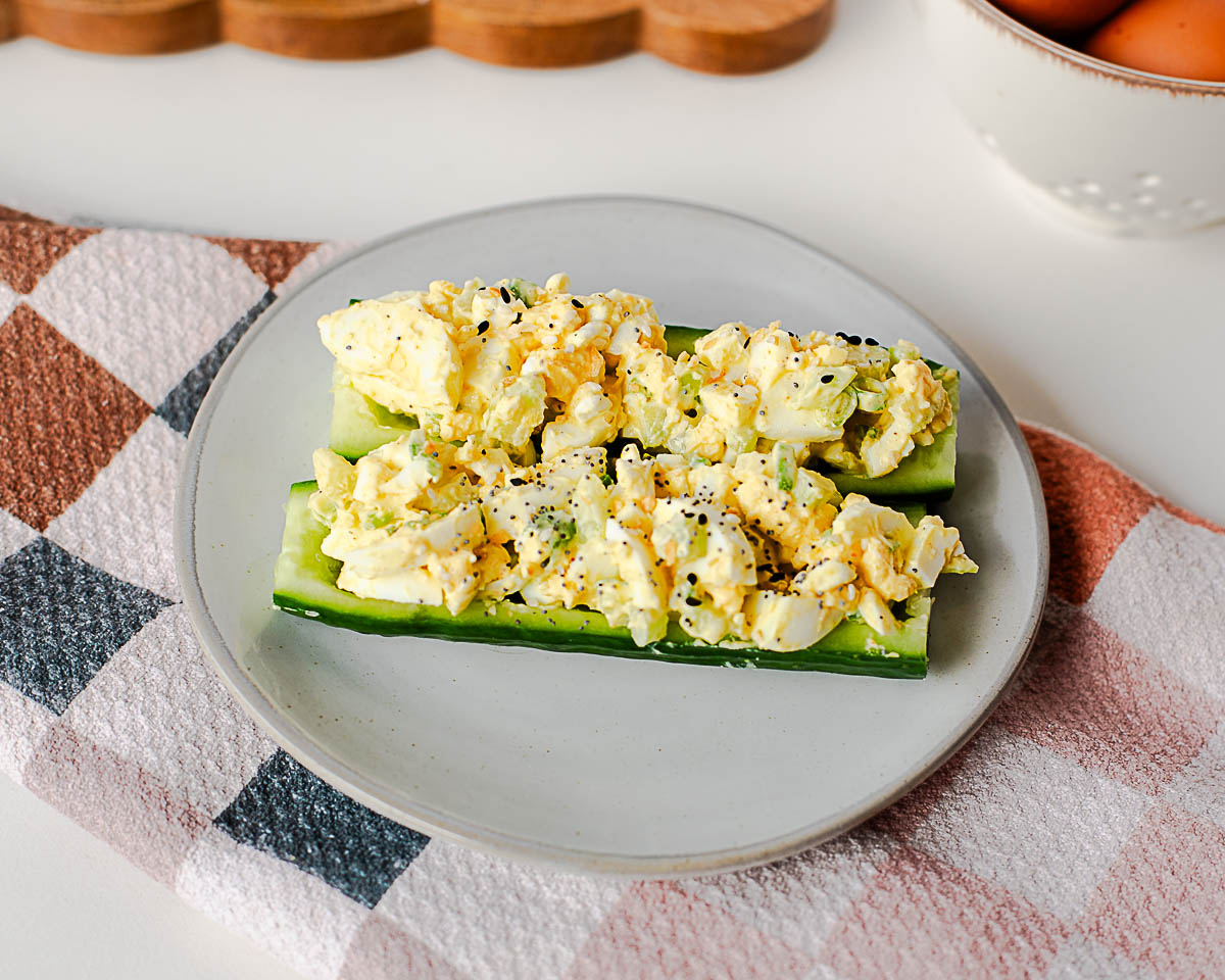 High-protein egg salad cucumber boats made with English cucumbers, chopped eggs, celery, and green onions for an easy healthy lunch.