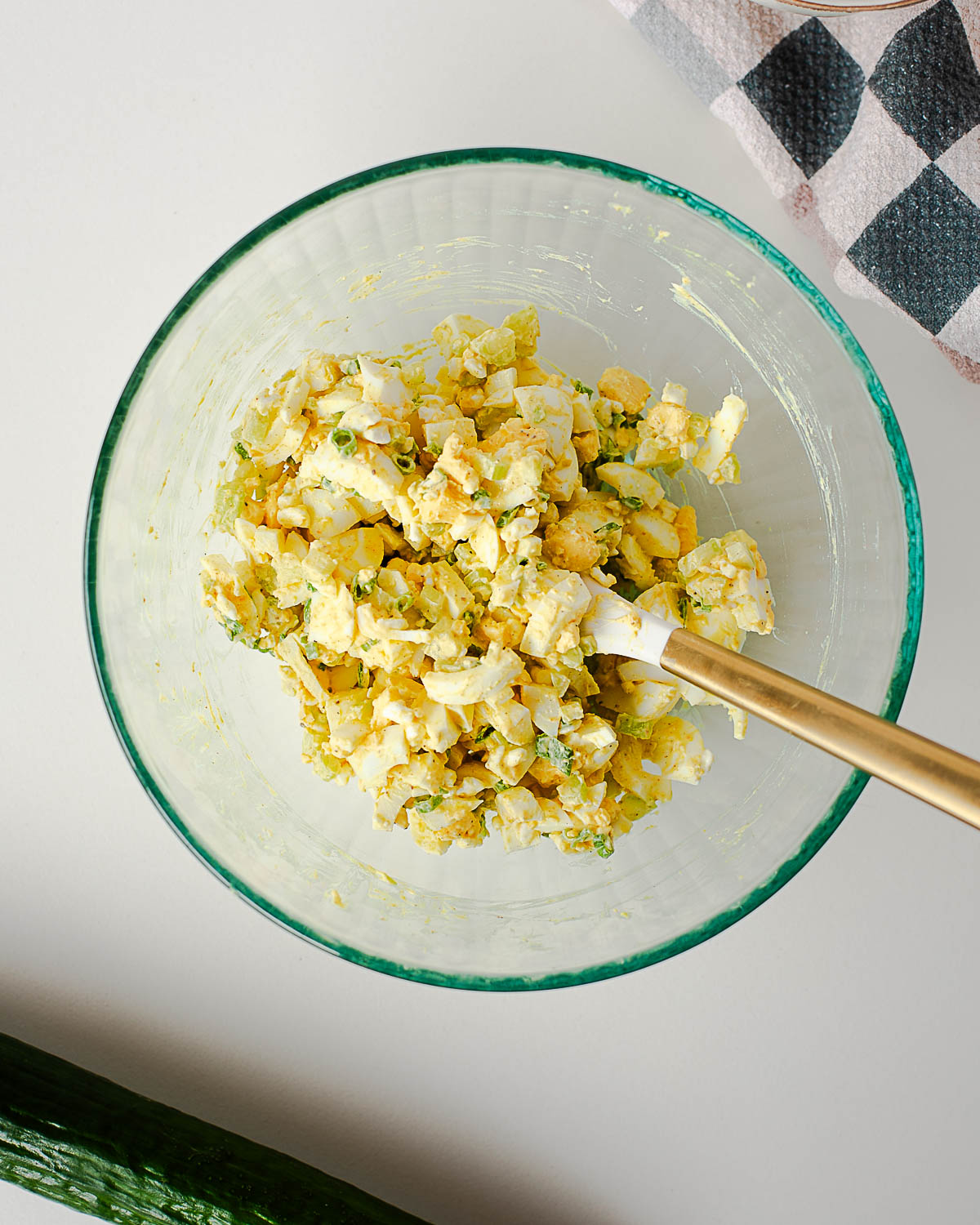 Creamy homemade egg salad mixed in a glass bowl with chopped eggs, celery, green onions, Greek yogurt, mayonnaise, and mustard.