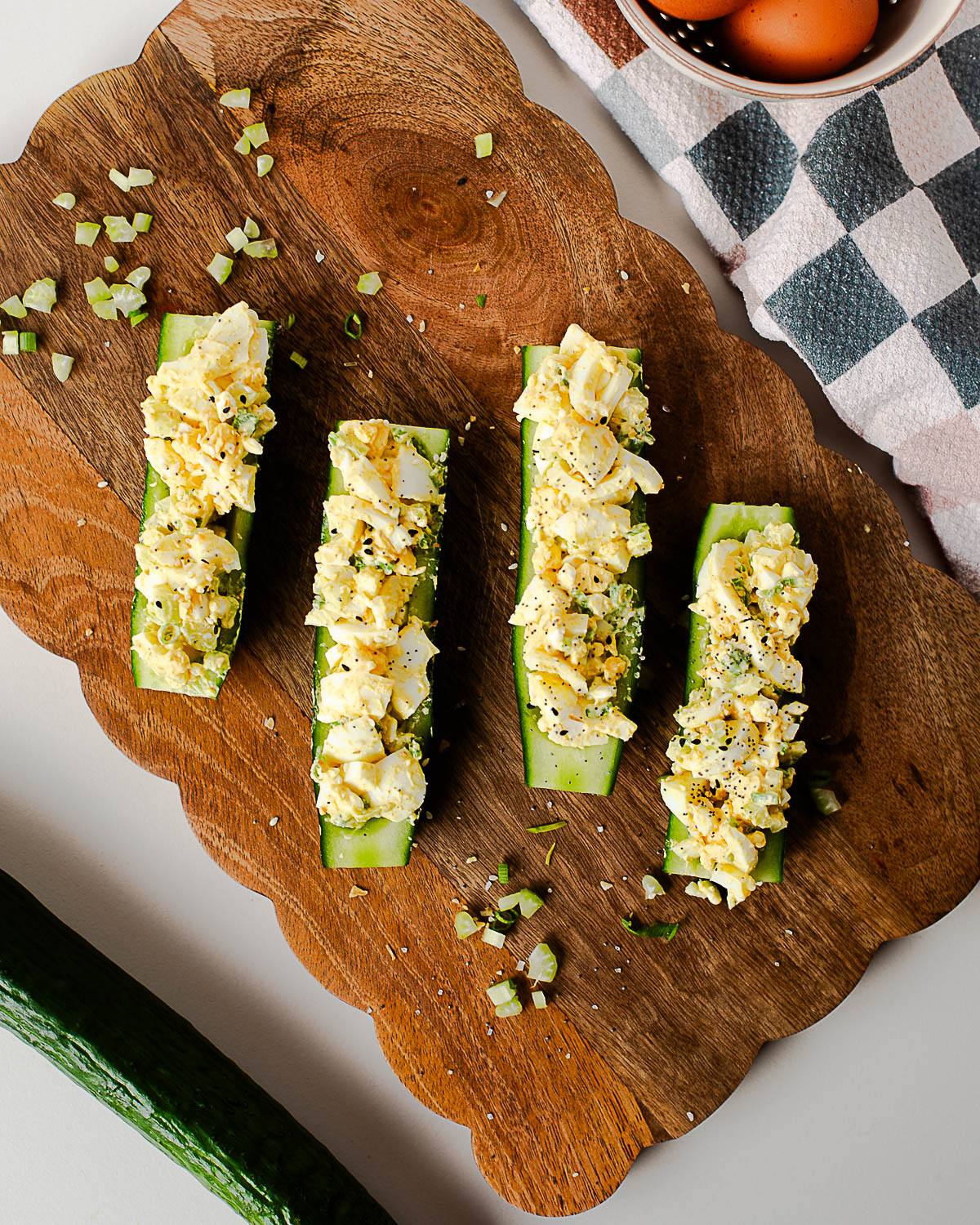 Egg salad cucumber boats plated and ready to serve, topped with everything bagel seasoning for extra flavor and crunch.