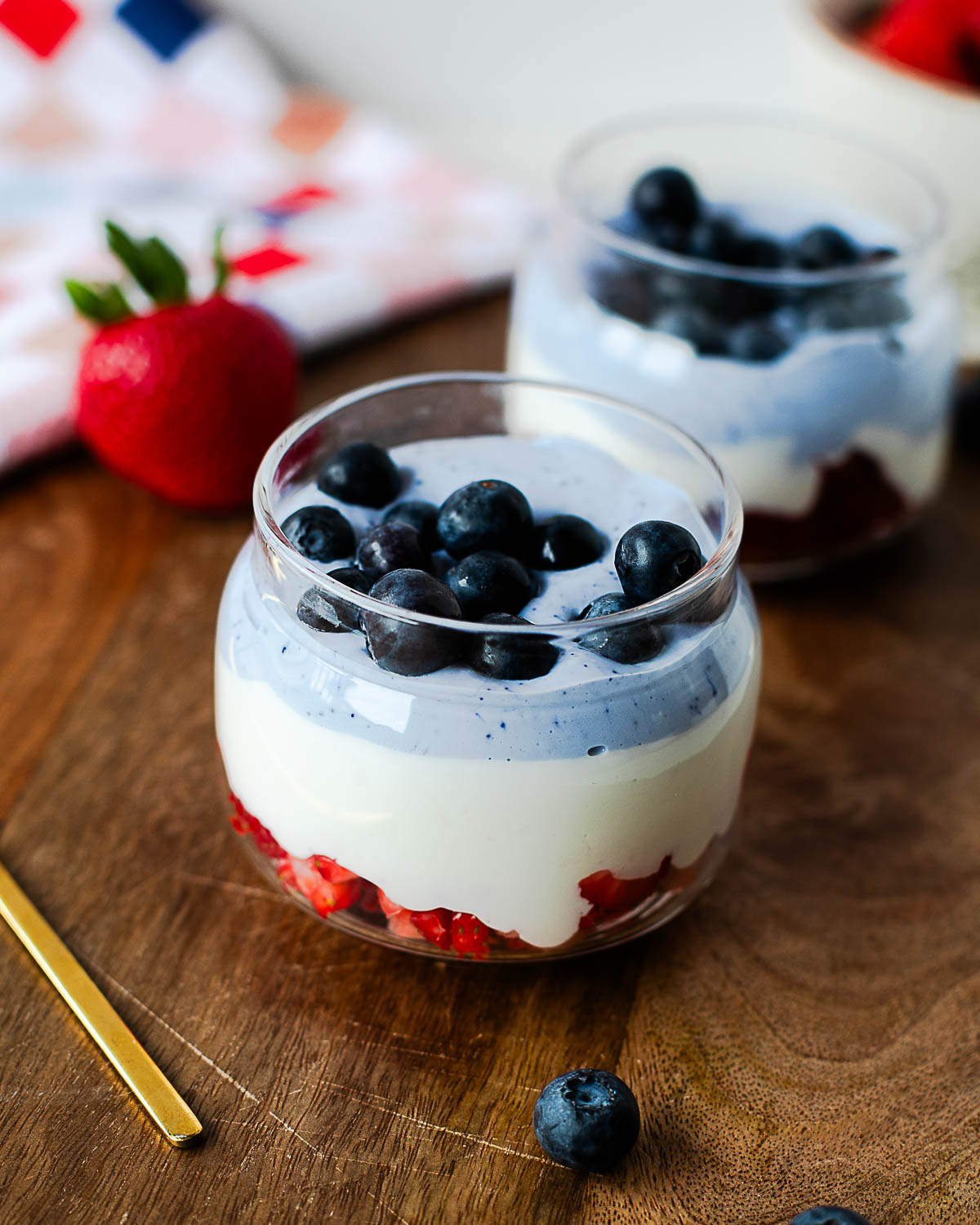 Smooth vanilla whipped cottage cheese and naturally blue butterfly pea flower cottage cheese with diced strawberries, ready to assemble into patriotic parfaits.