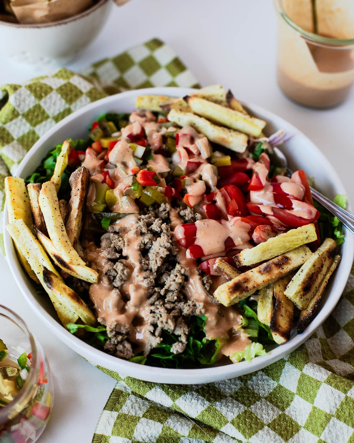 Healthy turkey burger bowl served with crispy sweet potato fries, fresh vegetables, pickle de gallo, and creamy special sauce for an easy high-protein meal.