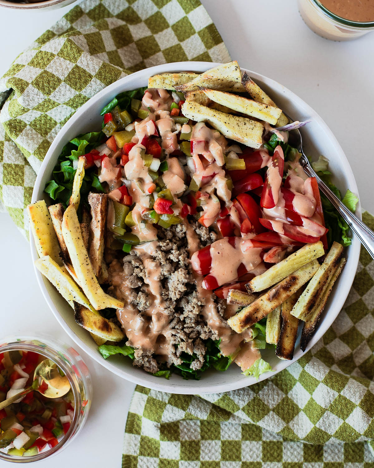 Turkey burger salad bowl with crispy sweet potato fries, pickle de gallo, grape tomatoes, lean ground turkey, and creamy special sauce.