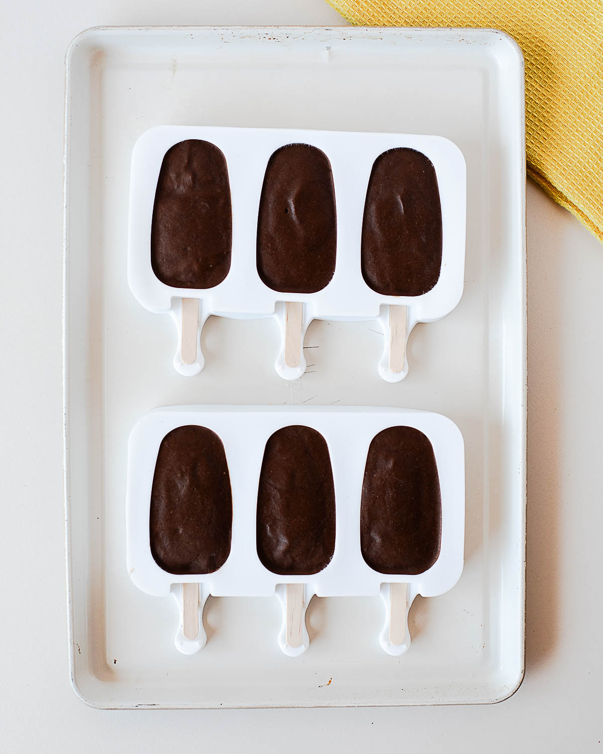 Homemade chocolate avocado popsicles frozen in silicone popsicle molds.