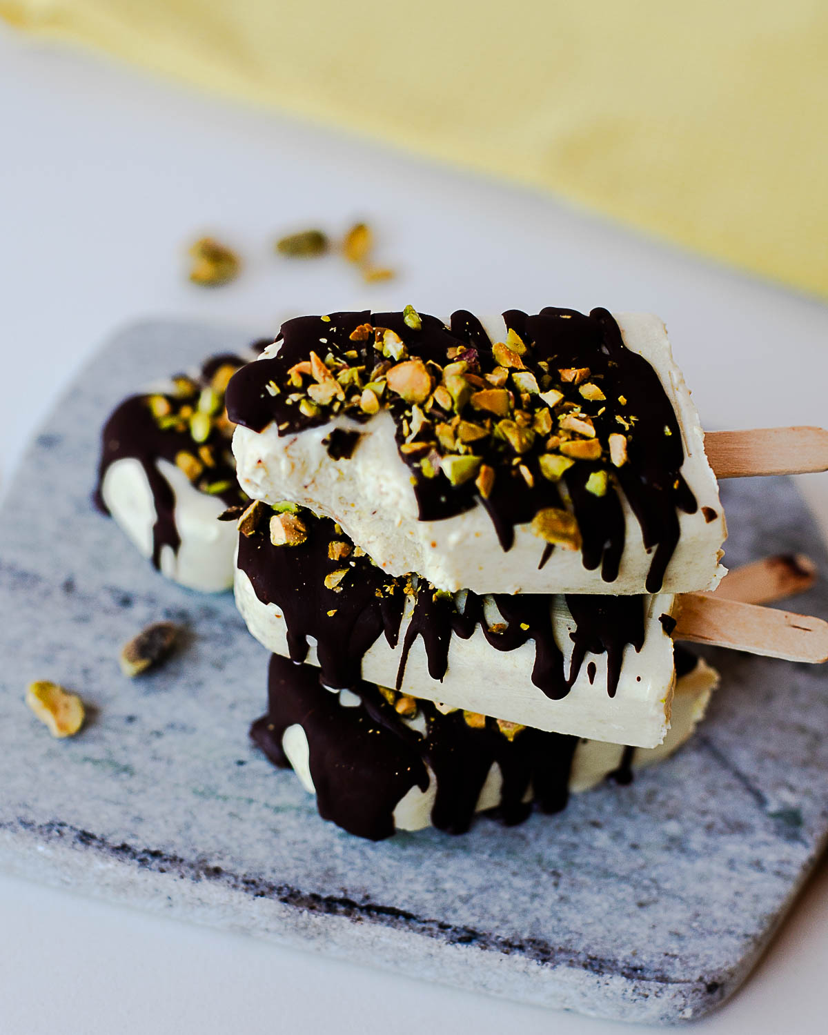 Easy homemade pistachio popsicles topped with dark chocolate and crushed pistachios.