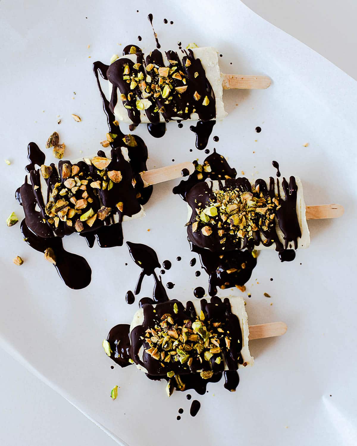 Pistachio popsicles drizzled with melted dark chocolate and topped with crushed pistachios.