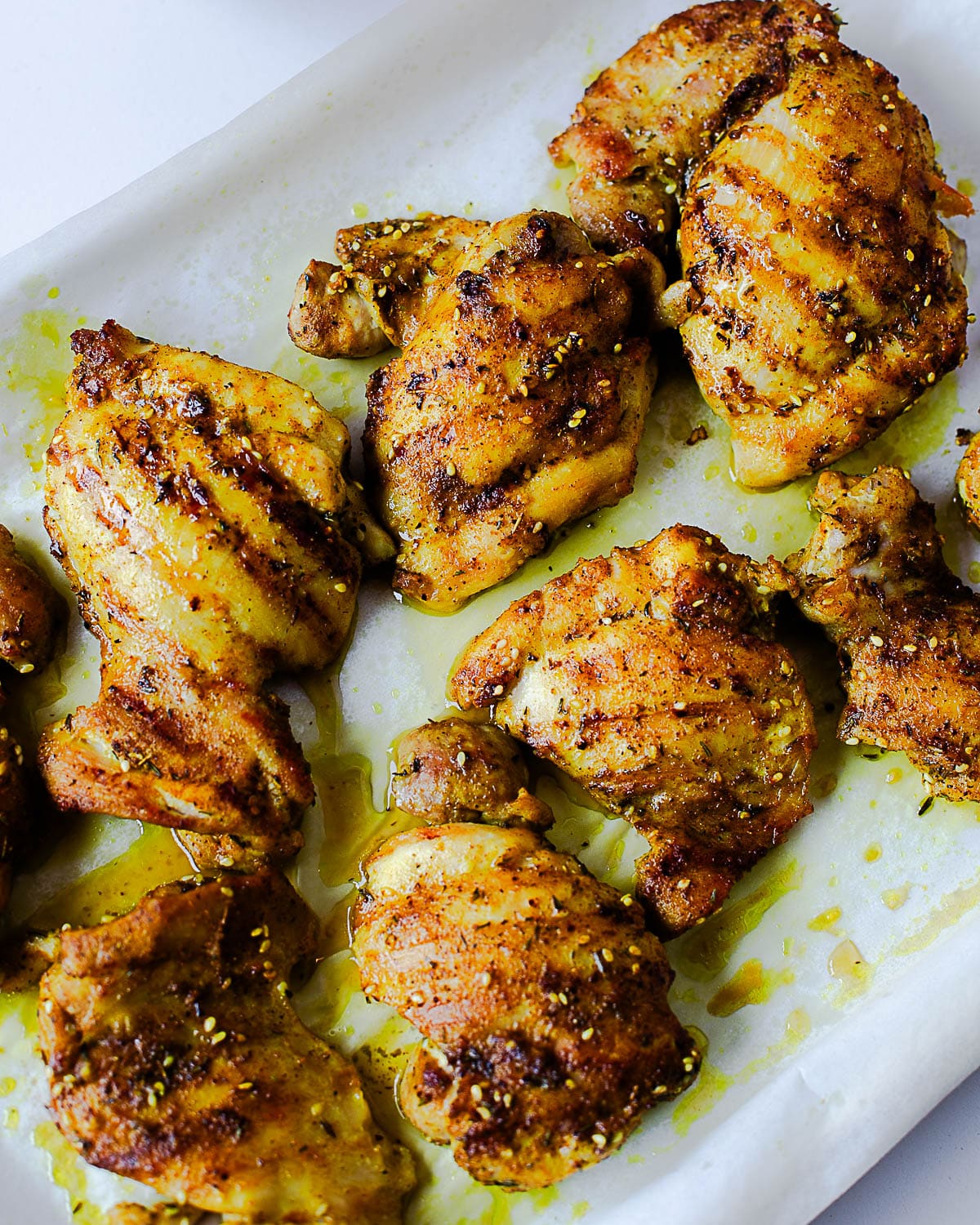 Close-up of juicy za’atar chicken thighs with golden brown edges, sesame seeds, and Middle Eastern spices.