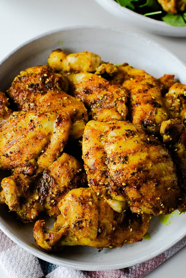 Golden za’atar chicken thighs served in a bowl, seasoned with turmeric, sesame seeds, and herbs.