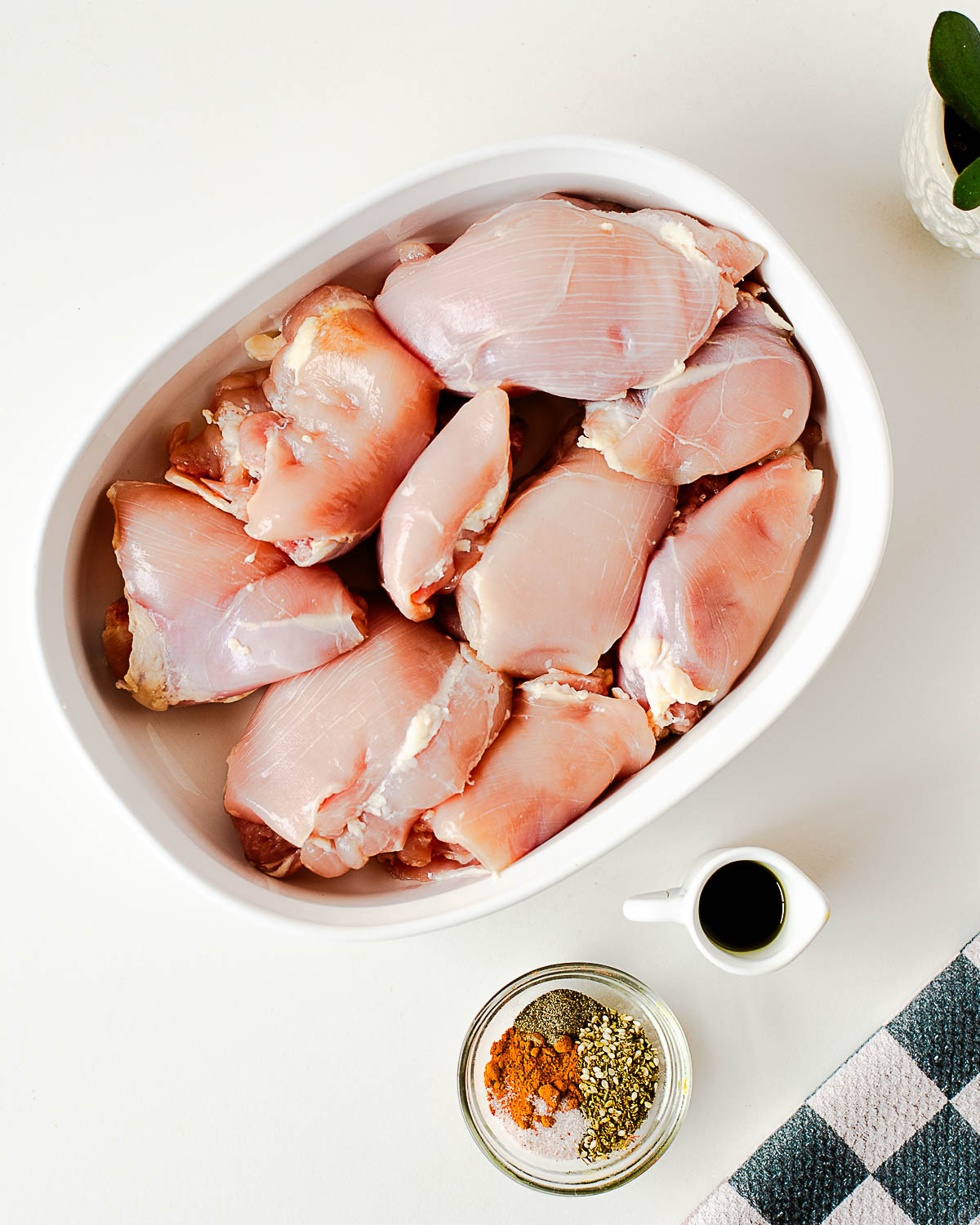 Boneless skinless chicken thighs with olive oil, za’atar spice, turmeric, sea salt, and black pepper ready for marinating.