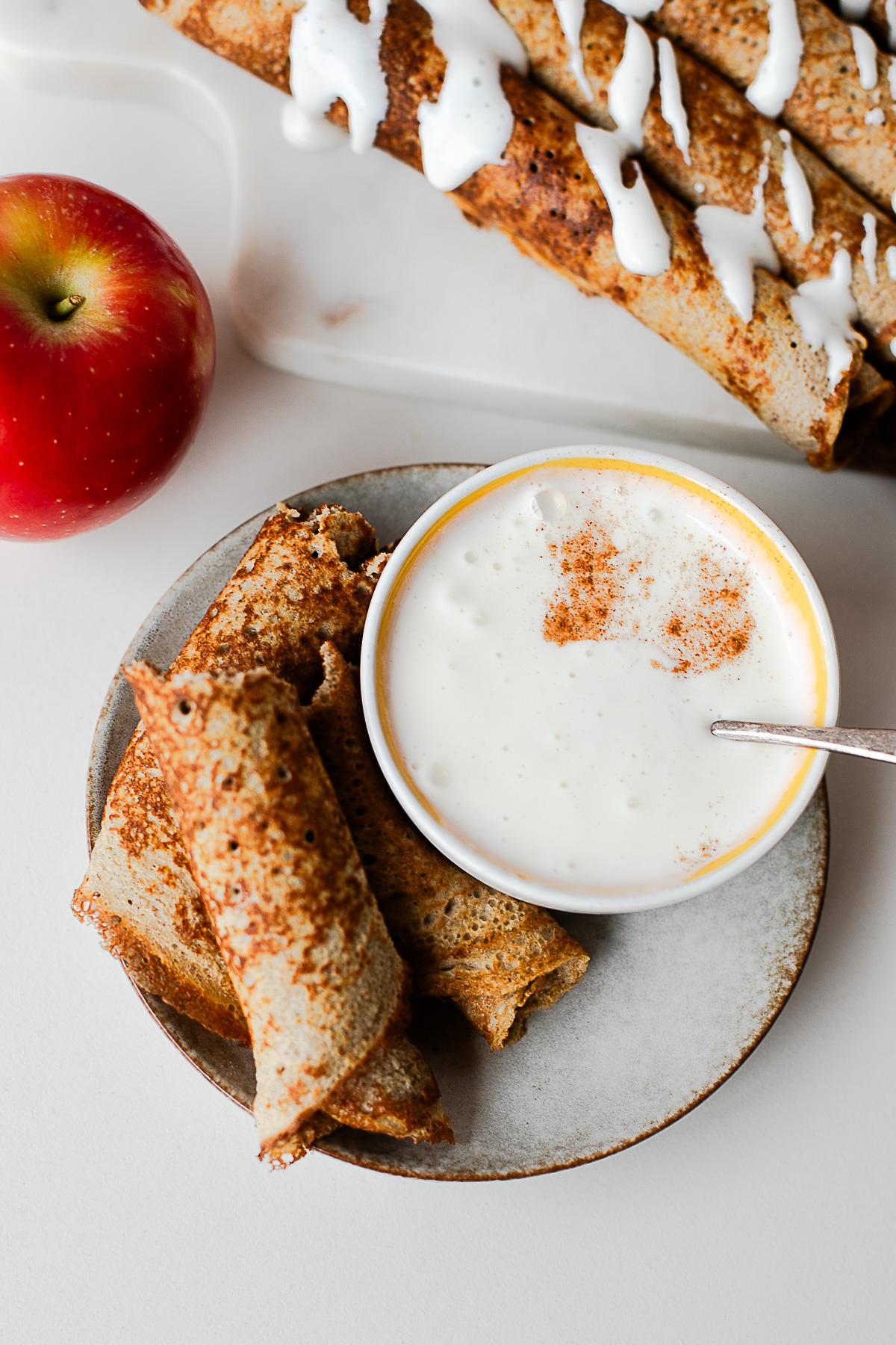Plate of sliced apple crepes with a bowl of cottage cheese honey dip