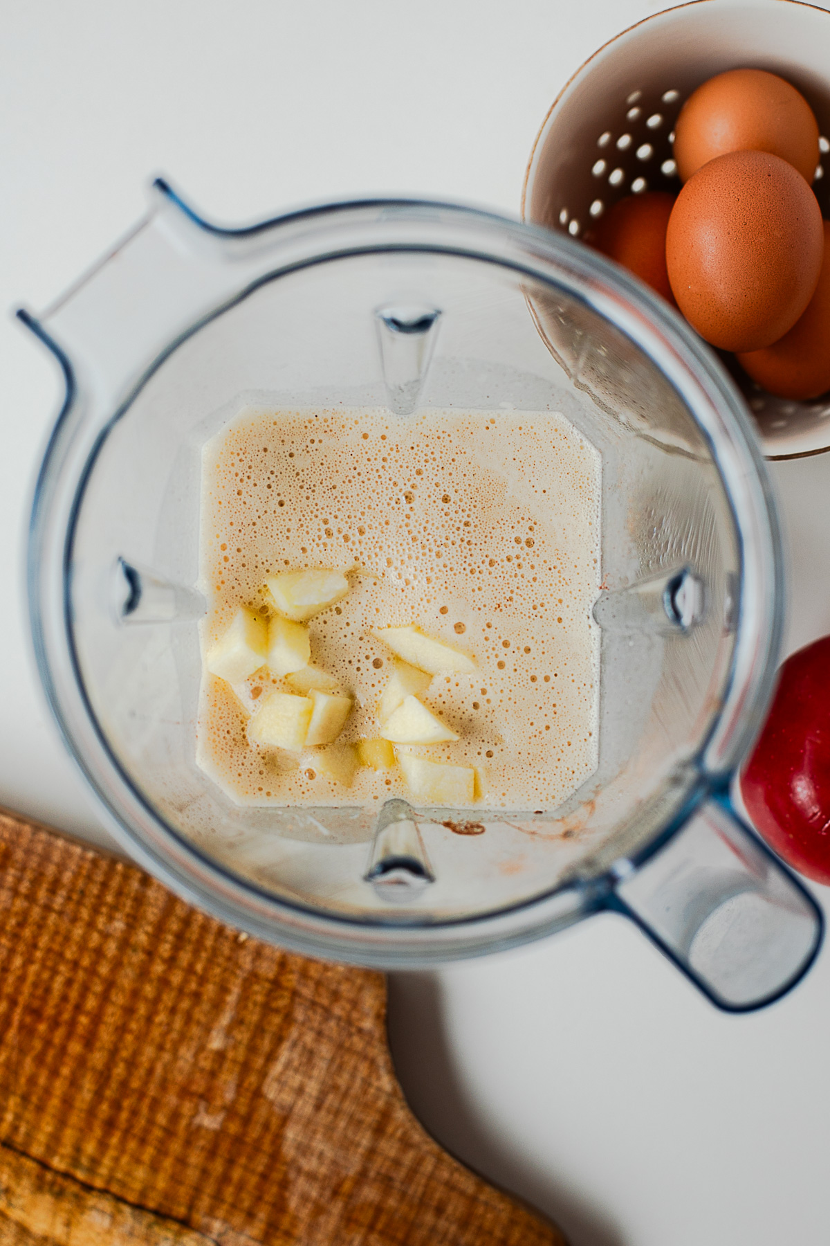 Diced apple added to cinnamon crepe batter in a blender