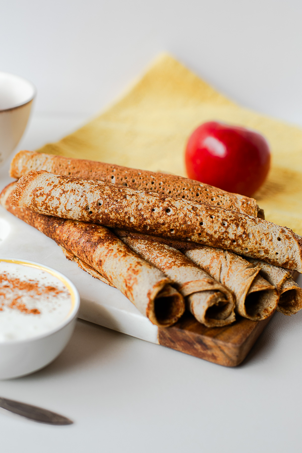 Rolled whole wheat apple crepes with a fresh apple