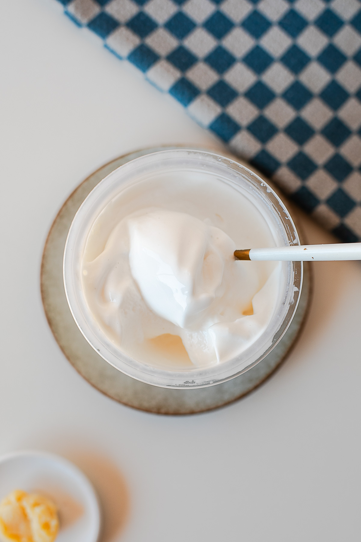Overhead shot of creamy browned butter protein ice cream in a Ninja Creami container with a spoon.