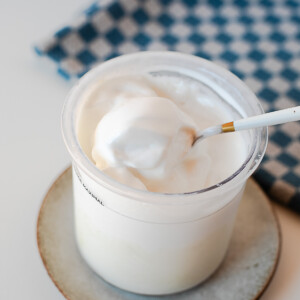 Close-up side view of creamy protein ice cream in the Ninja Creami container with a spoon.