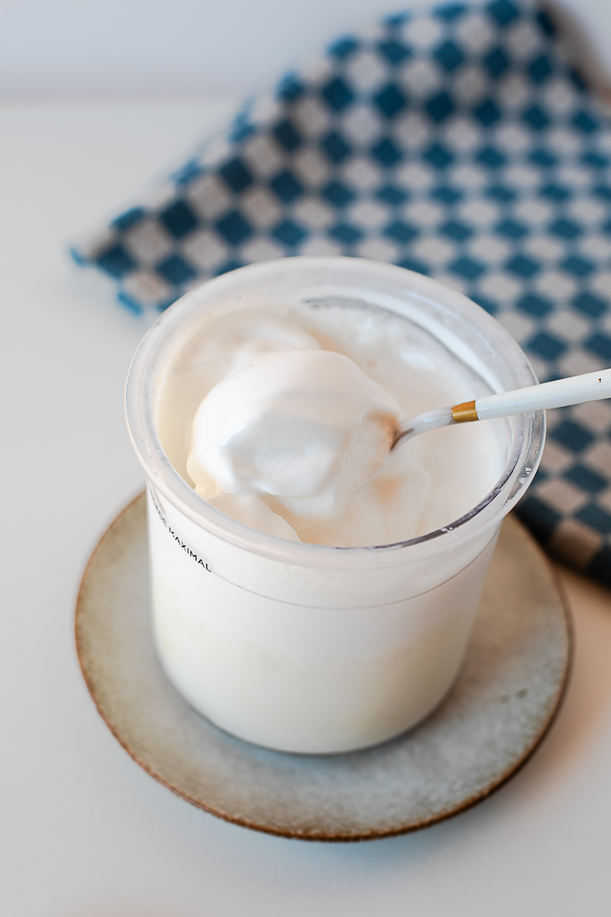 Close-up side view of creamy protein ice cream in the Ninja Creami container with a spoon.
