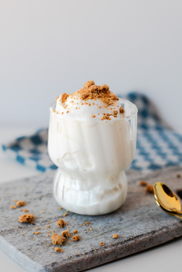 Side view of browned butter protein ice cream served in a glass dessert cup, topped with crushed cookie crumbs.