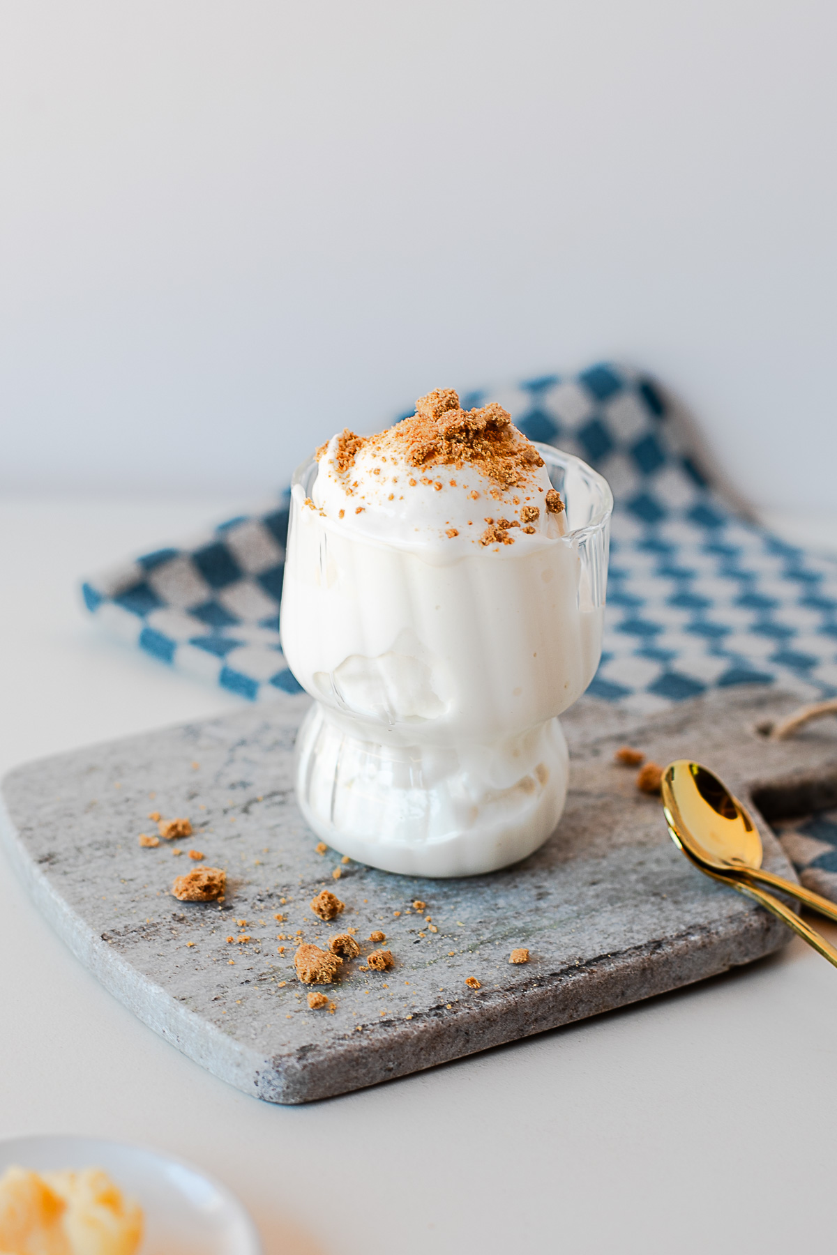 Front view of browned butter protein ice cream in a glass dessert cup topped with cookie crumbs.