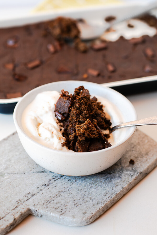 Bowl of warm chocolate spoon cake with ice cream on a marble board