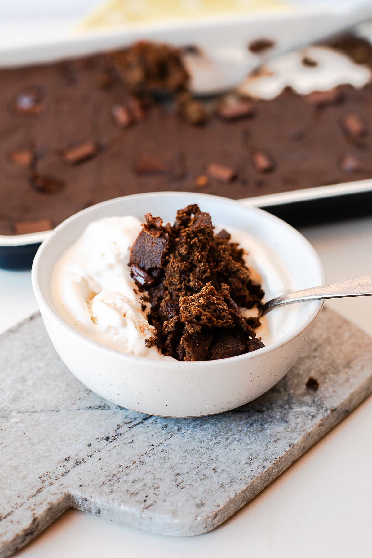 Bowl of warm chocolate spoon cake with ice cream on a marble board
