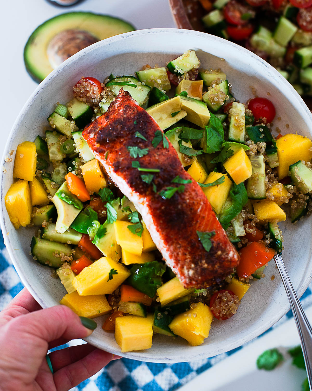 Close up of a hot honey salmon quinoa bowl showing the flaky salmon and fresh toppings