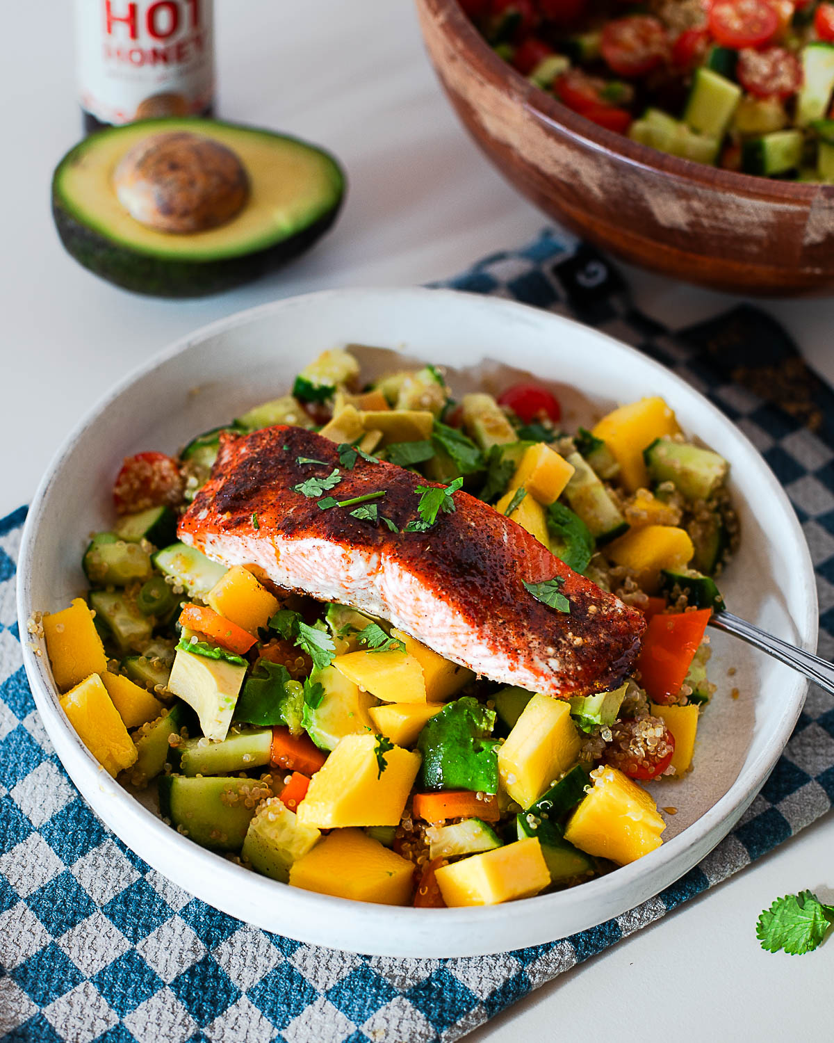 Hot honey salmon quinoa bowl with mango, avocado and cherry tomatoes, ready to eat