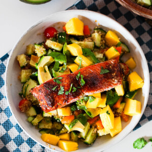 Overhead shot of a hot honey salmon bowl topped with mango, avocado and fresh cilantro