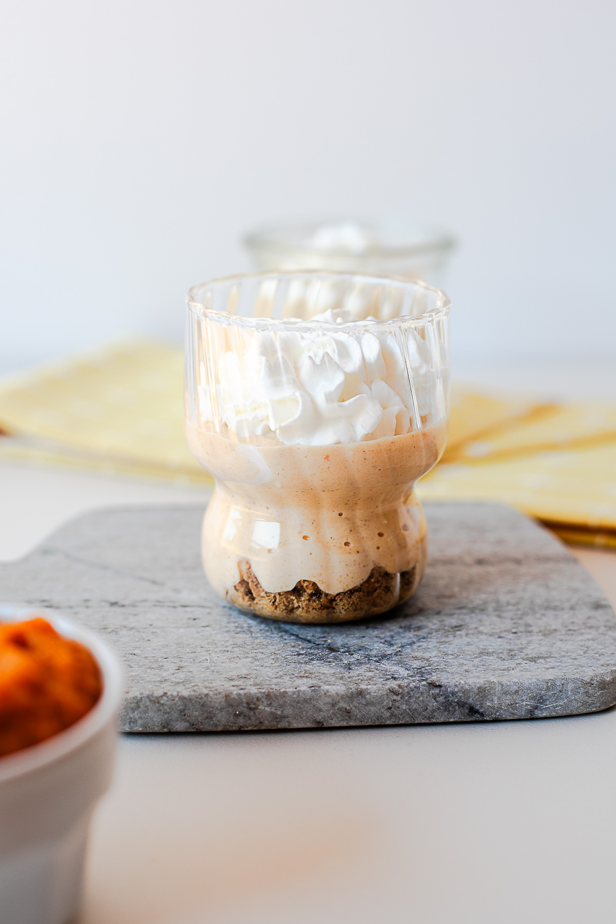 Pumpkin pie yogurt layered over crushed cookies in a jar and topped with whipped cream