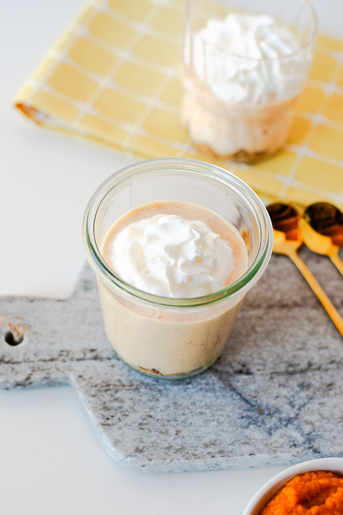 Close-up of pumpkin pie yogurt in a glass jar topped with whipped cream