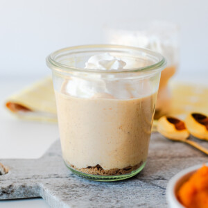 Glass jar of pumpkin pie Greek yogurt with whipped cream on a marble board