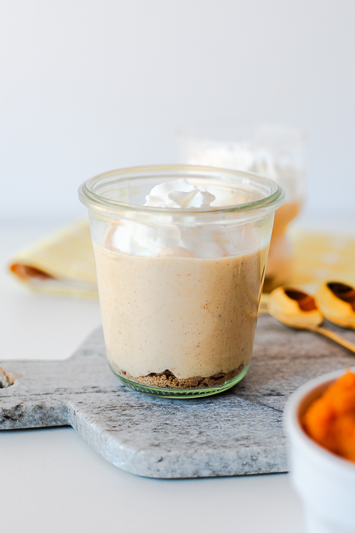 Glass jar of pumpkin pie Greek yogurt with whipped cream on a marble board