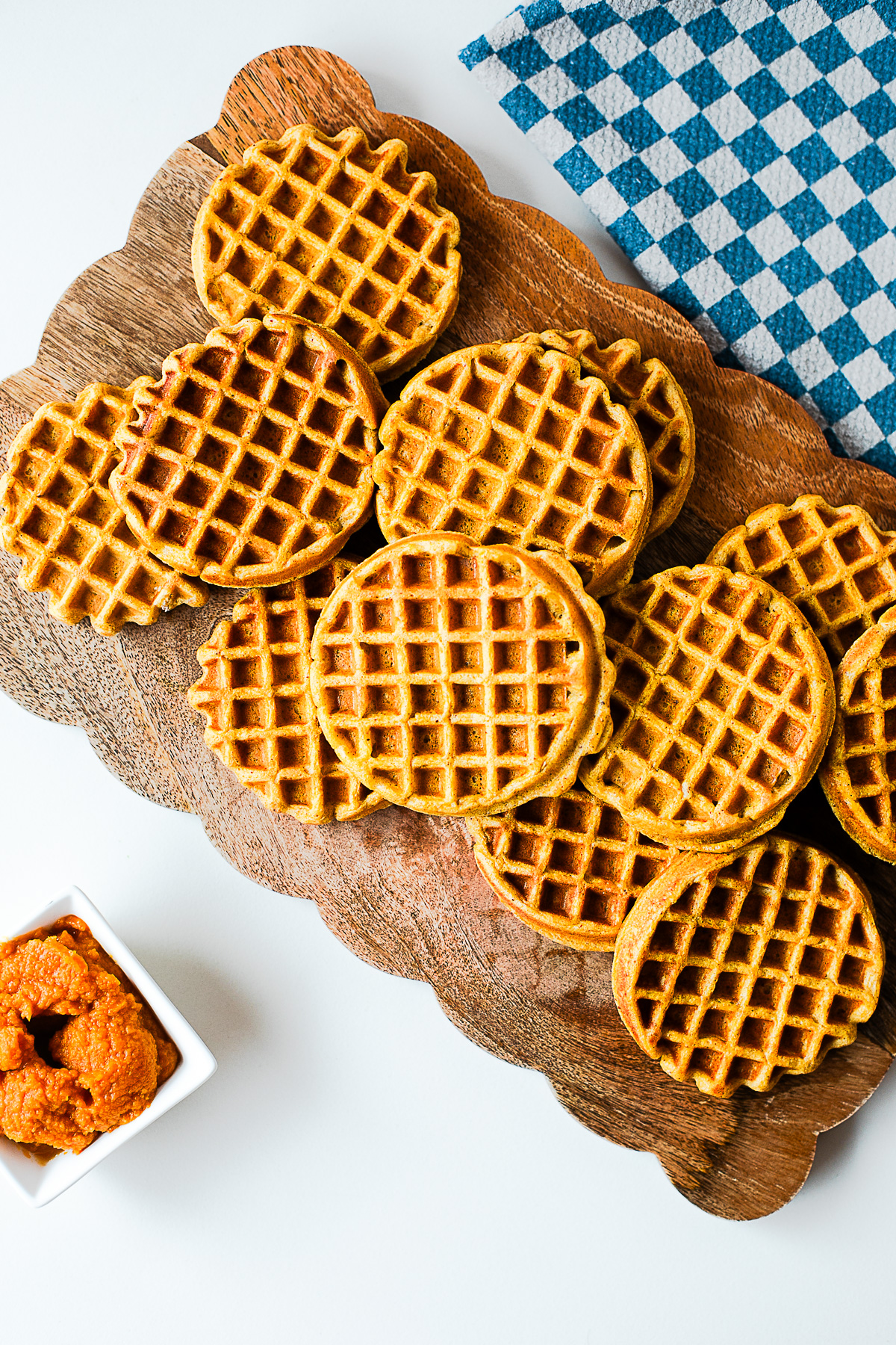 Golden pumpkin protein waffles on a wooden serving board